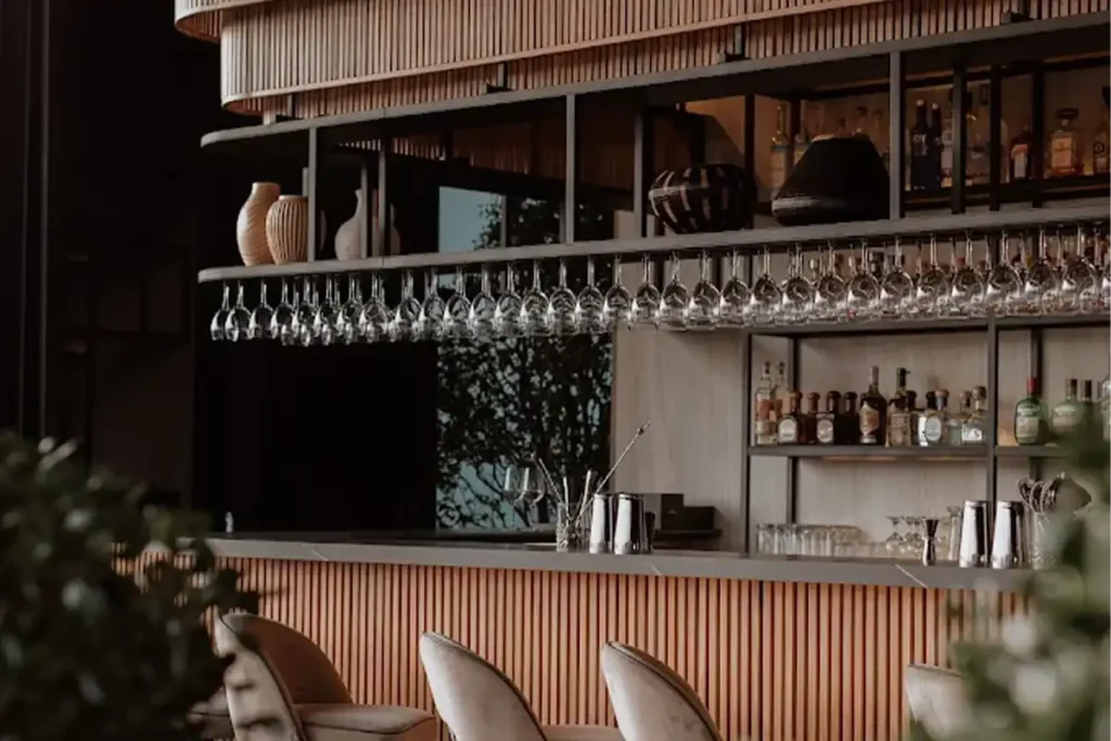 Diseño de barra moderna en Etro Rooftop Medellín: cristalería colgante, acabados en madera y barra de licores premium.