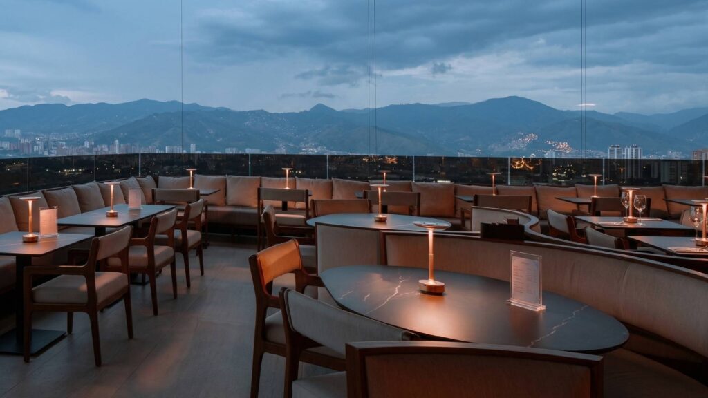 Brunch con vista panorámica a las montañas de Medellín en Etro Rooftop con ambiente elegante y mesas iluminadas al atardecer