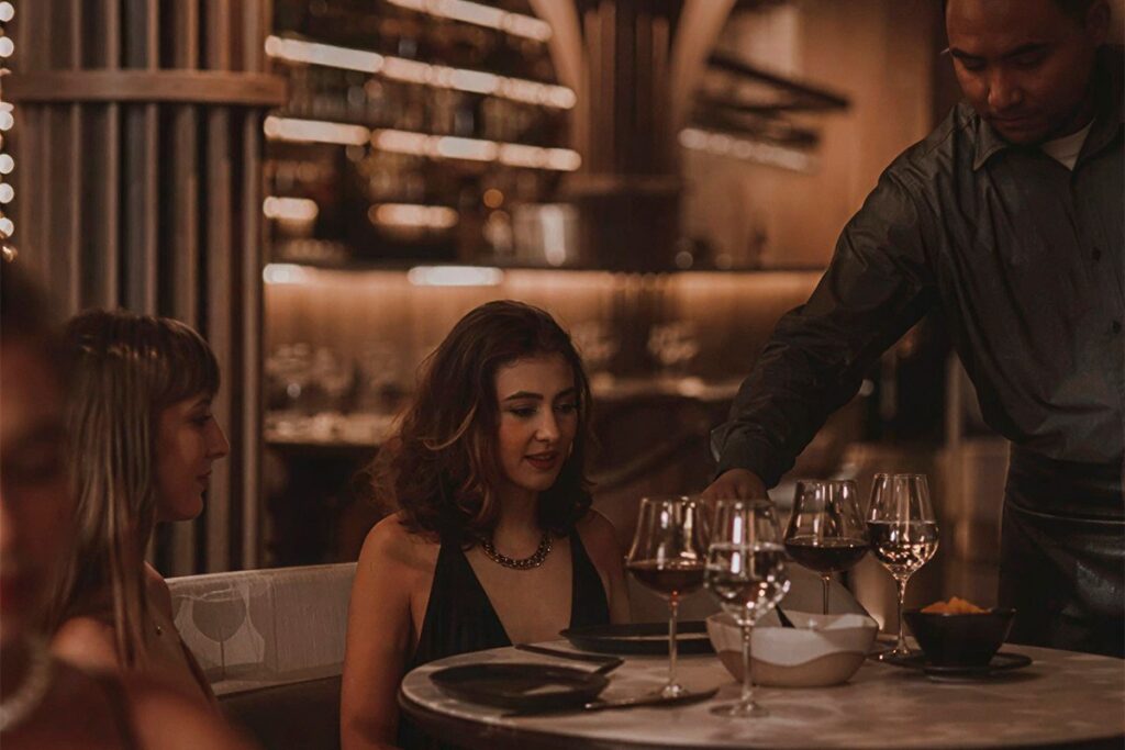 Cena elegante en el restaurante La Makha de Medellín con servicio de vino y ambiente íntimo para grupos exclusivos.