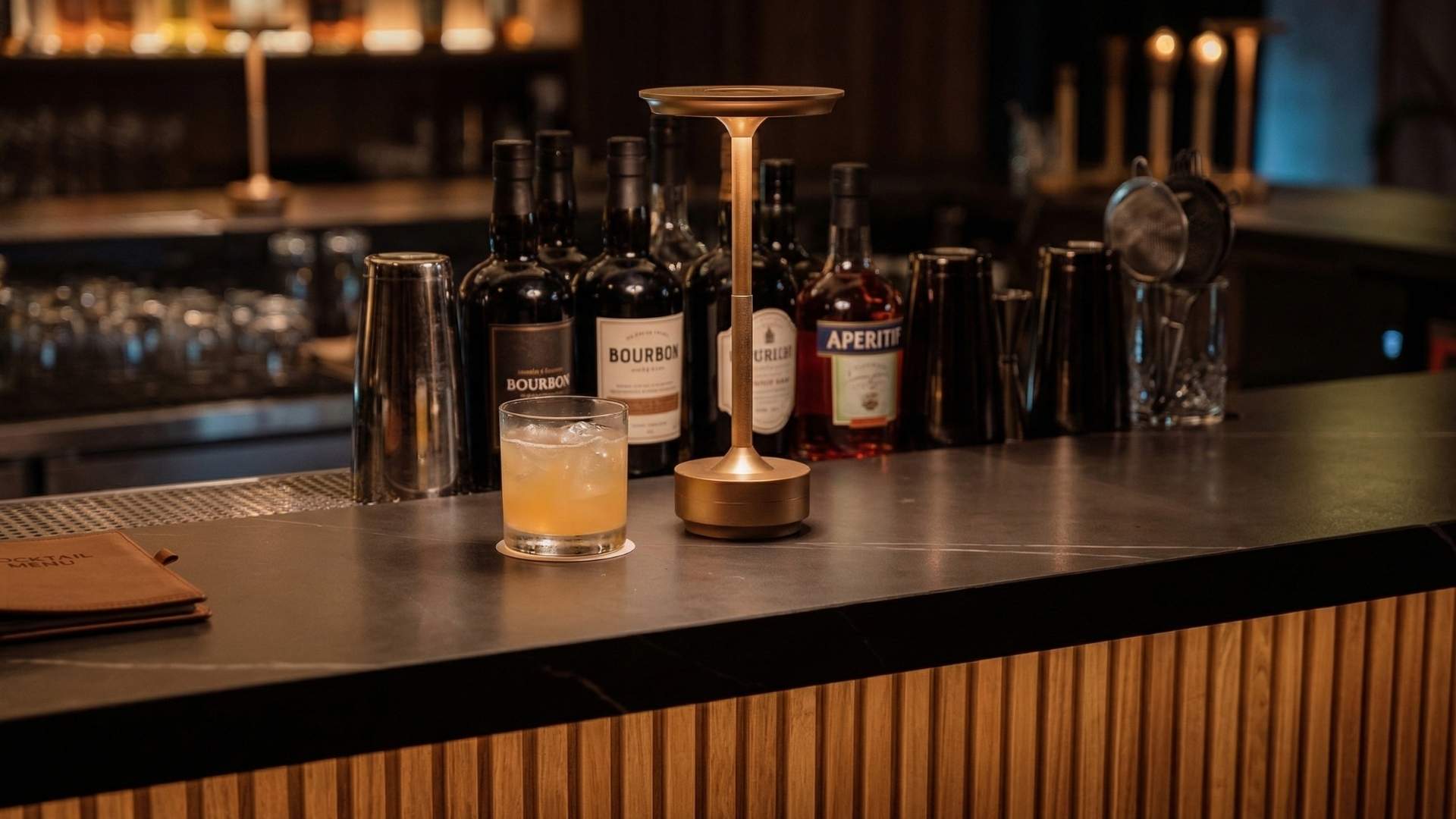 Cóctel artesanal con ingredientes locales servido en rooftop de Medellín con barra elegante y selección de licores premium de fondo