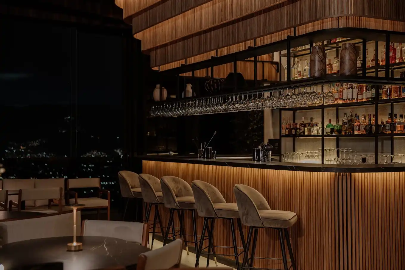 Detalle de mesa reservada en Etro Rooftop Medellín: tarjeta personalizada en dorado, flores blancas y ambiente de lujo.