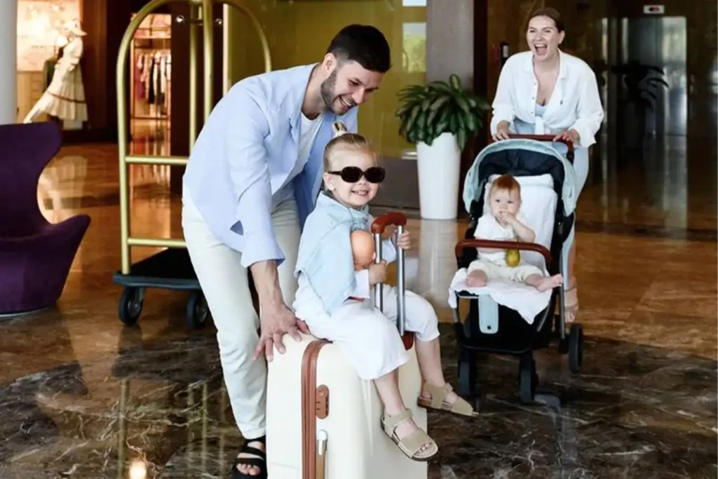 Check-in divertido en Binn Hotel familiar en Medellín: padres con niños y maletas en el elegante lobby.