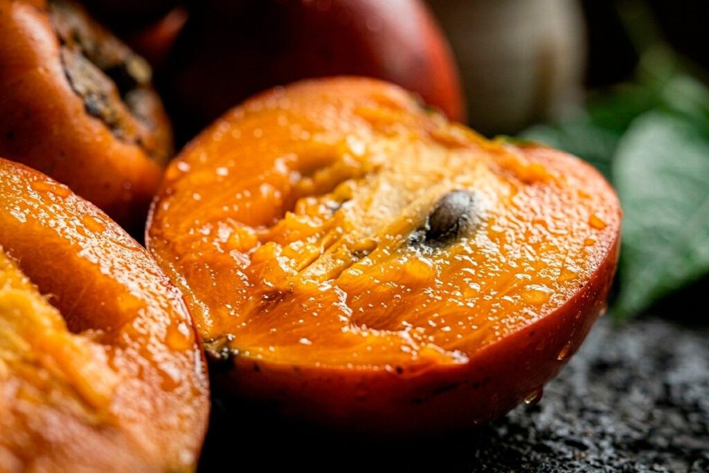 Fruta local de Antioquia partida a la mitad con textura jugosa y semillas visibles en preparación gastronómica gourmet