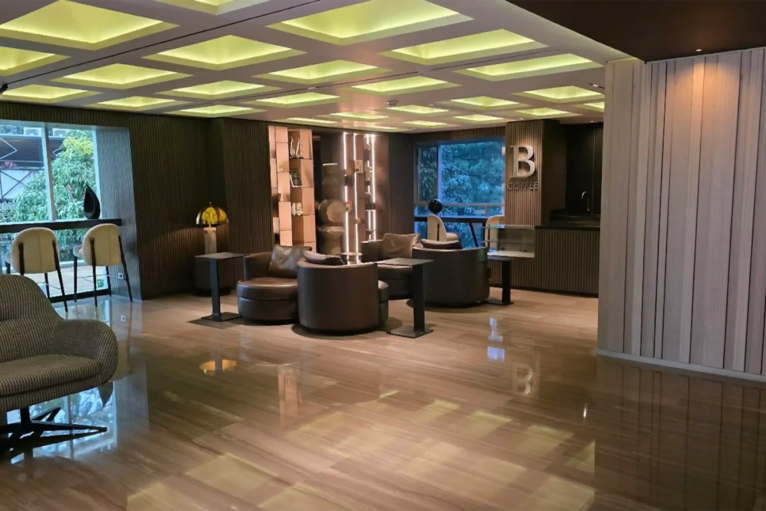 Lobby elegante de uno de los mejores hoteles ejecutivos en Medellín, con zona de coworking, café y mobiliario moderno.