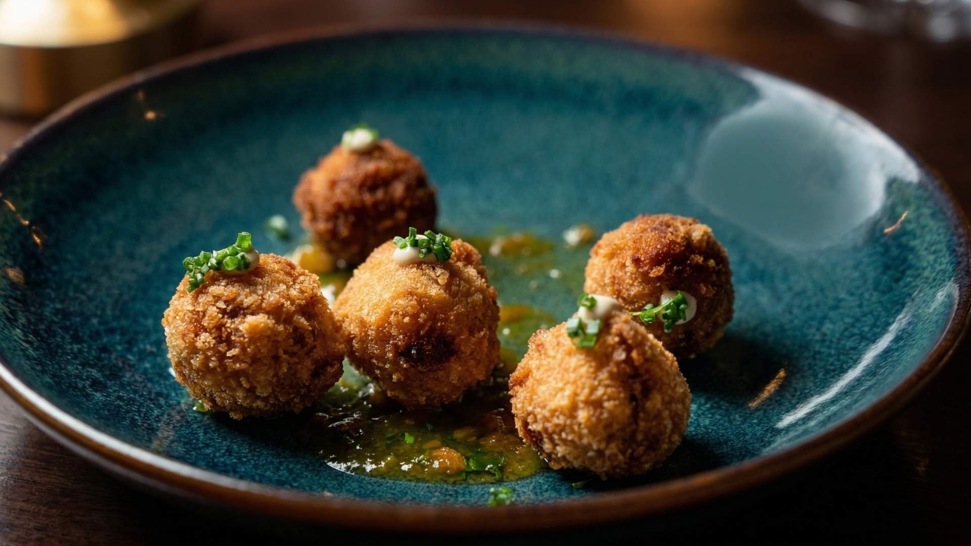 Croquetas vegetarianas gourmet servidas en Etro Rooftop Medellín con salsa verde y presentación elegante en plato moderno.