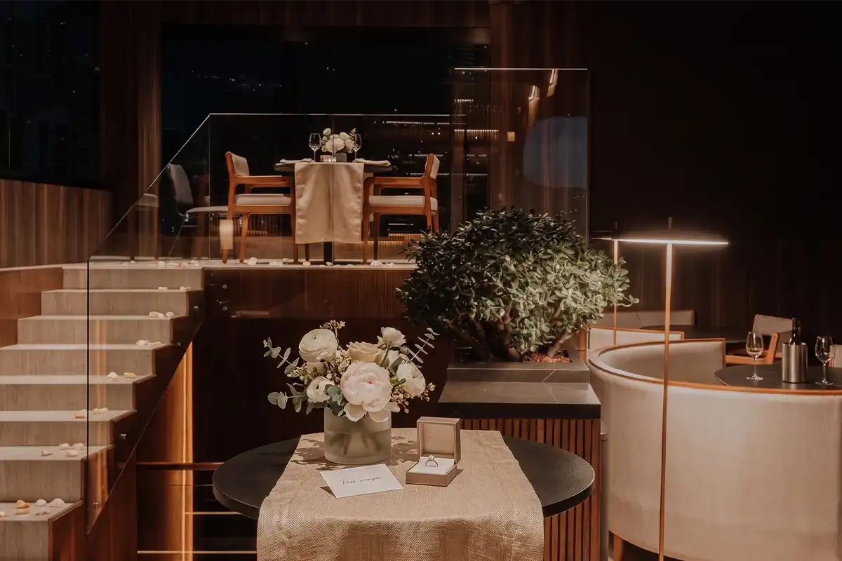 Propuesta de matrimonio en Etro Rooftop Medellín: anillo de compromiso, flores blancas y cena romántica privada.