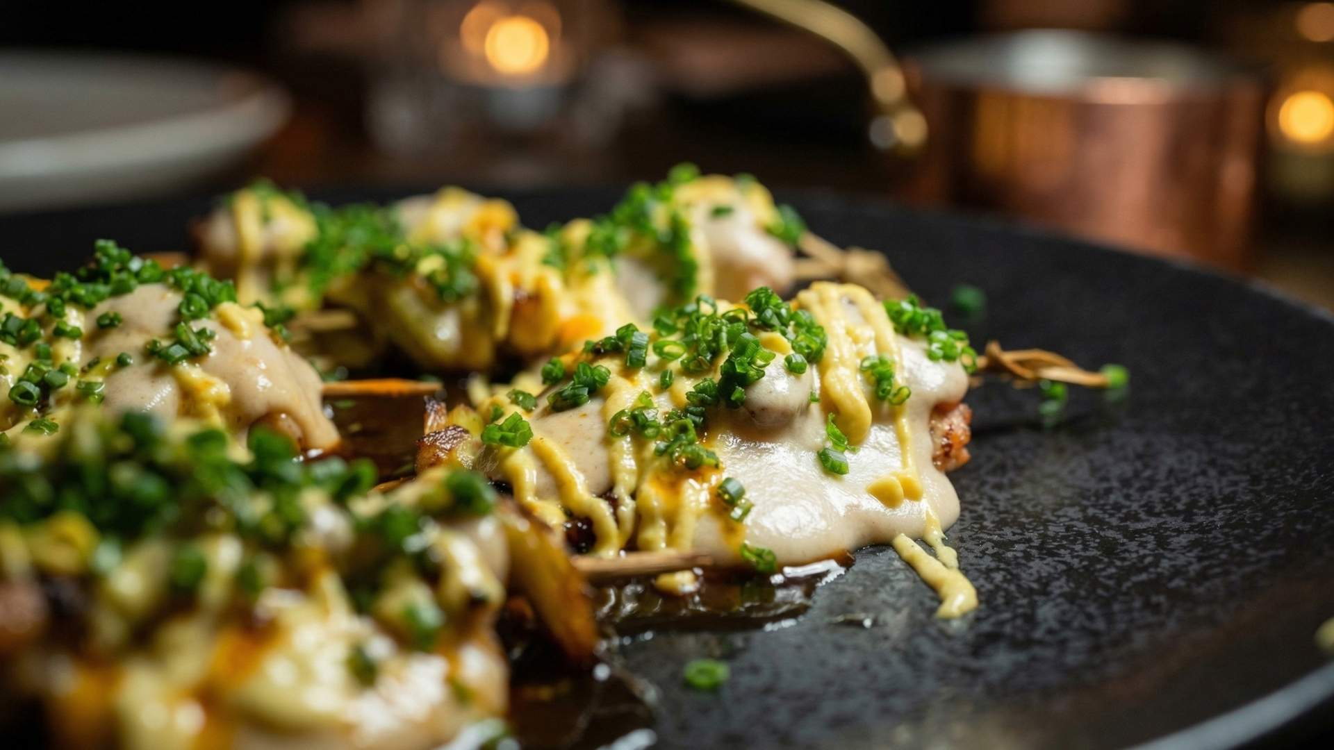 Plato de comida fusión gourmet en rooftop de Medellín con presentación moderna y ambiente nocturno elegante