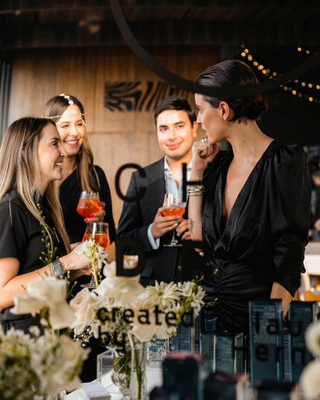 Personas brindando en rooftops con agenda cultural en Medellín, evento social elegante con cócteles y ambiente exclusivo en terraza urbana.