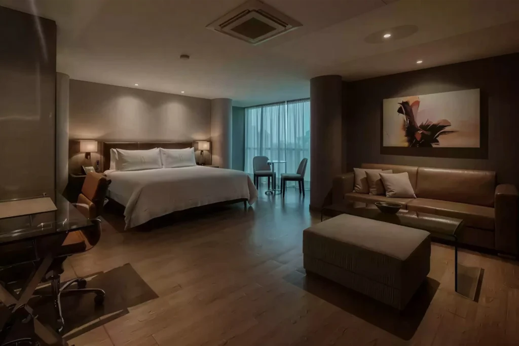 Suite de lujo en BINN Hotel con cama king, zona de estar y escritorio, disponible con tarifas flexibles para ejecutivos.