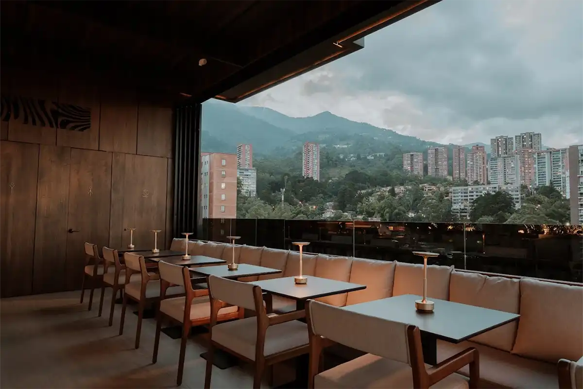Terraza para reuniones ejecutivas en Binn Hotel Medellín, con mesas privadas y vista panorámica a El Poblado.