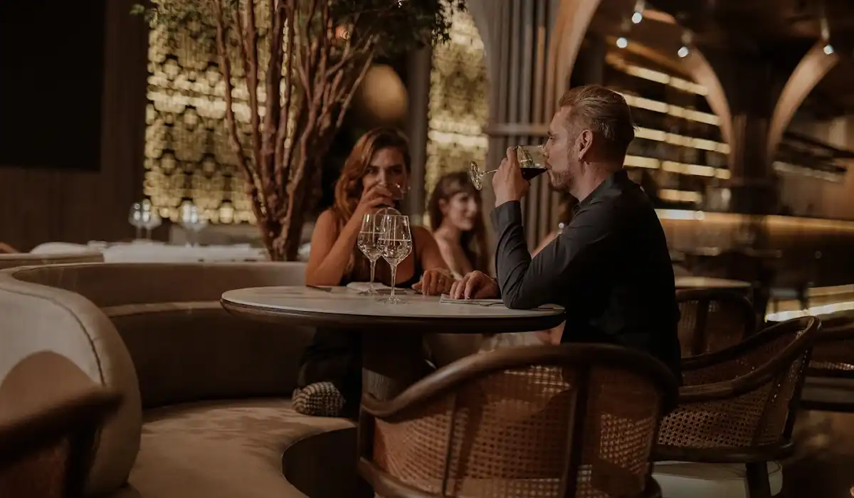 Pareja en cena romántica con vino en La Makha, restaurante de BINN Hotel, escapada romántica en Medellín mayo.