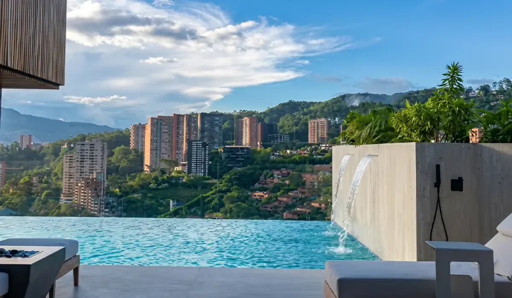Piscina infinita con cascada y vista a El Poblado desde rooftop de BINN Hotel, Medellín.