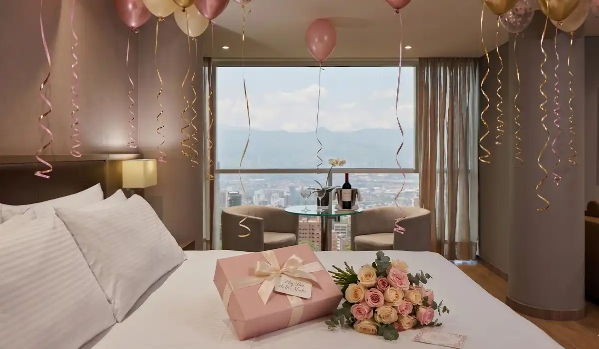 Habitación de BINN Hotel decorada con globos, rosas y regalo para el Día de las Madres, con vista a Medellín.
