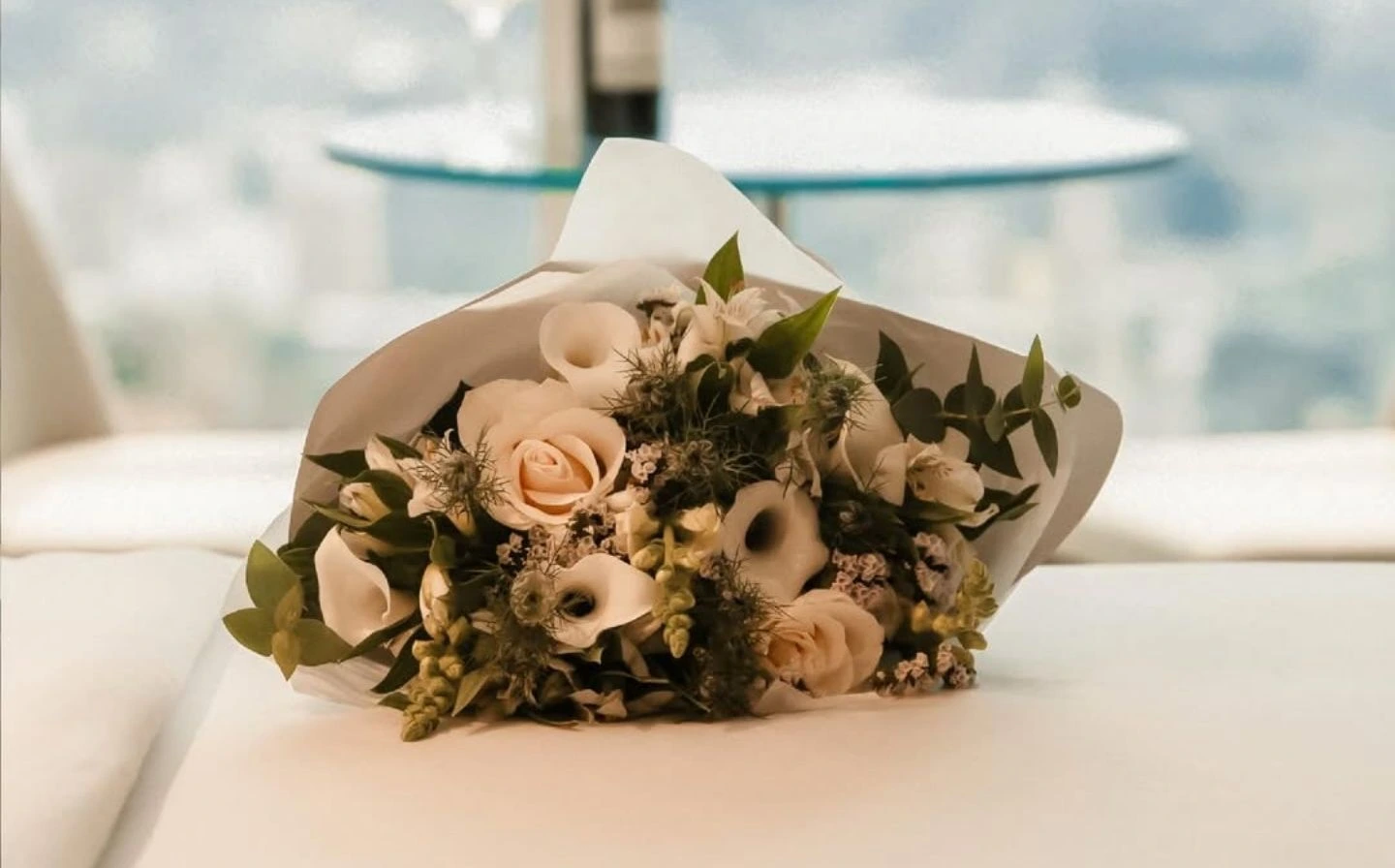 Ramo de rosas y calas blancas sobre cama de suite en BINN Hotel, detalle de bienvenida para el Día de las Madres en Medellín.