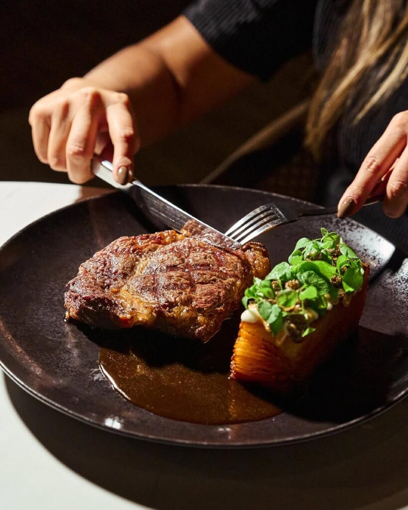 Plato de alta cocina para celebrar experiencias para mamá en La Makha Restaurante; carne a la brasa y papas milhojas.