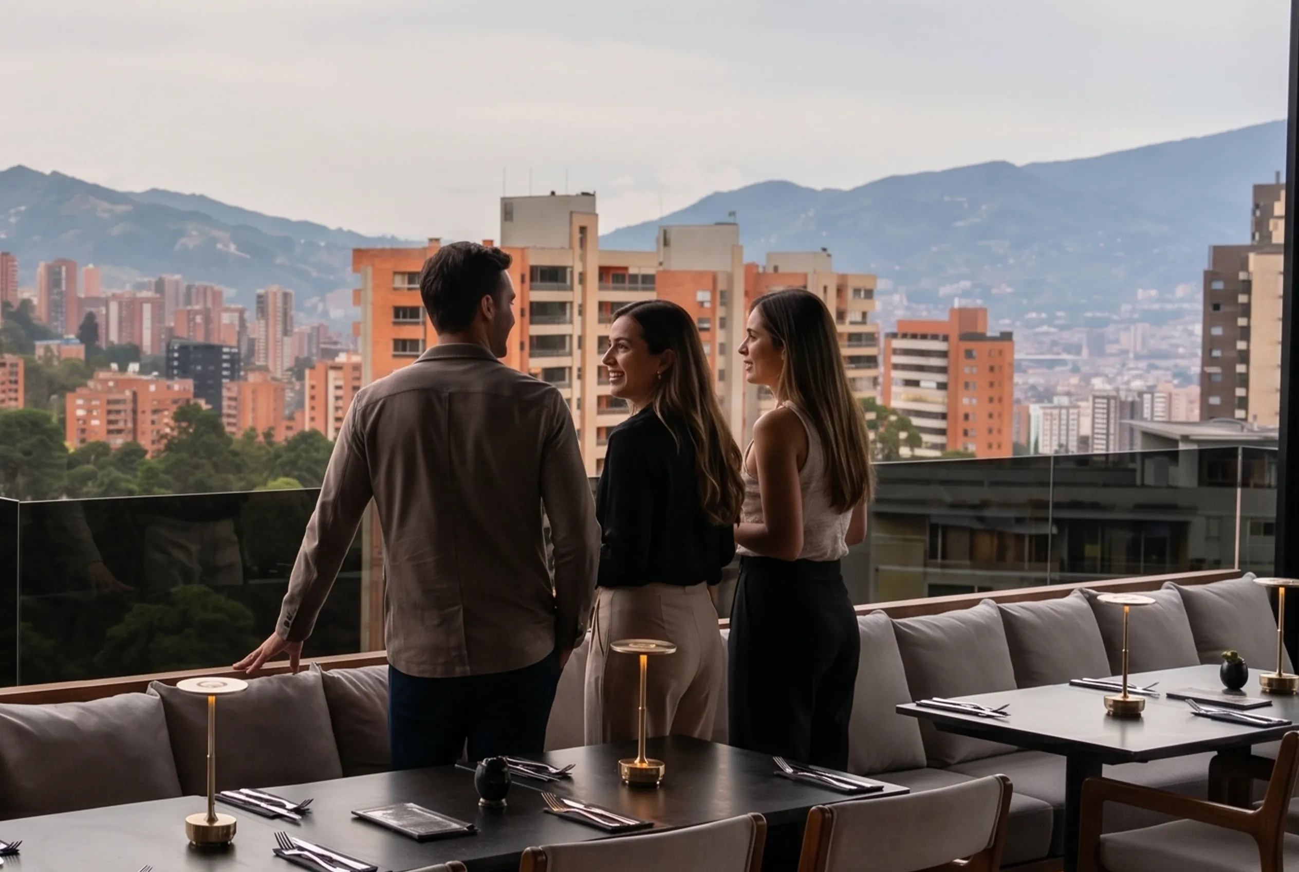 Tres visitantes descubriendo la terraza de ETRO Rooftop con vista a El Poblado de día, guía para novatos en BINN Hotel Medellín.