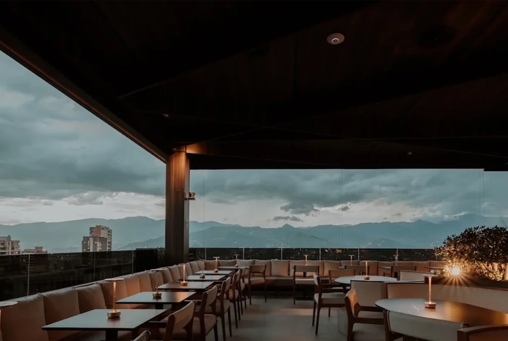 Terraza de ETRO Rooftop con sofás lounge y vista a la cordillera de los Andes al atardecer, mayo en BINN Hotel Medellín.

