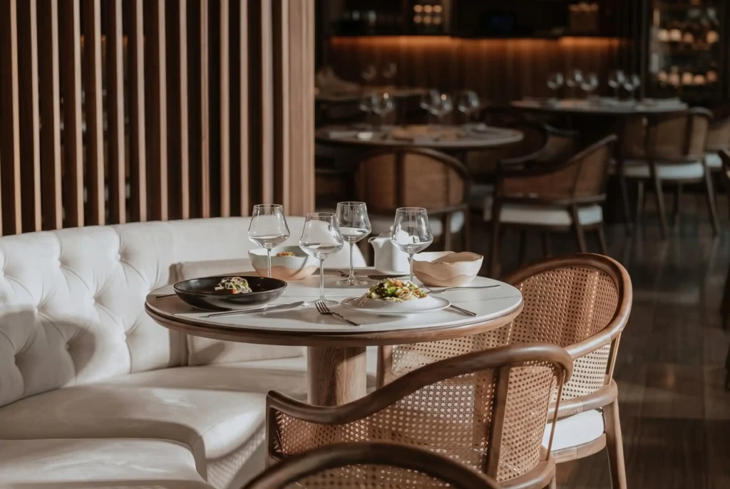 Mesa elegante con platos gourmet y sillas de mimbre, reflejando las tendencias gastronómicas 2026 en Medellín.