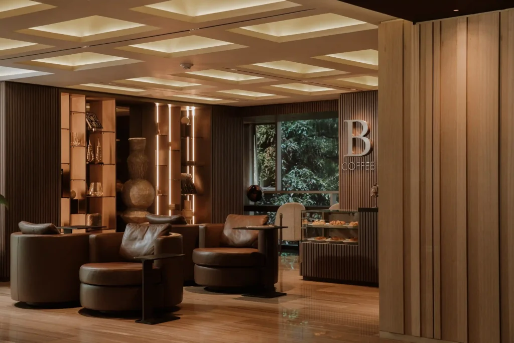B Coffee lounge area at BINN Hotel lobby with leather armchairs and pastry display case
