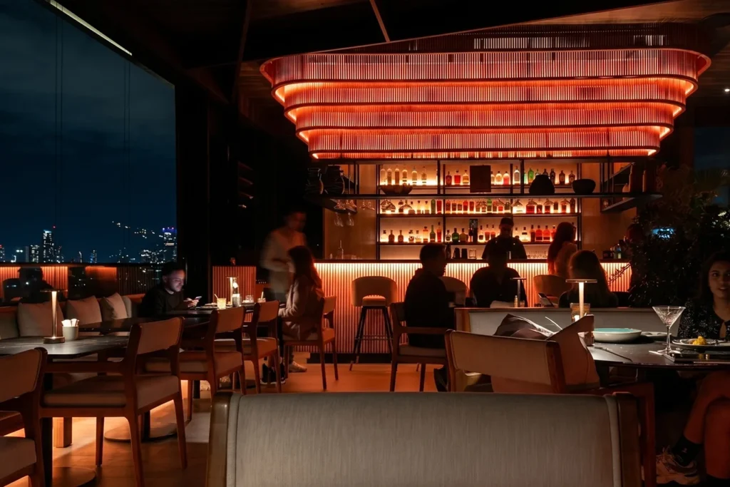 Ambiente nocturno de Etro Rooftop en Binn Hotel con barra iluminada y skyline de Medellín al fondo.