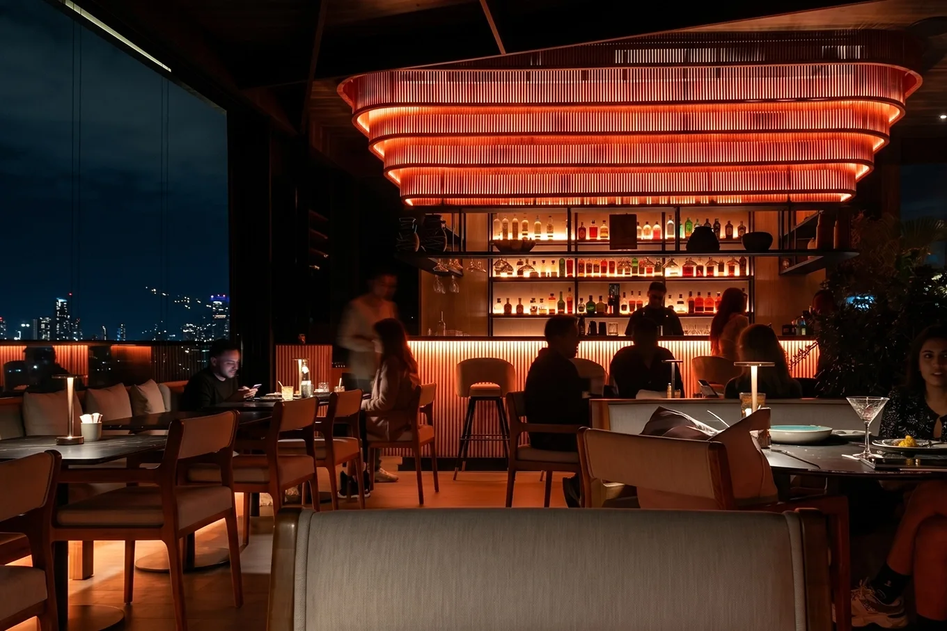 Ambiente nocturno de Etro Rooftop en Binn Hotel con barra iluminada y skyline de Medellín al fondo.