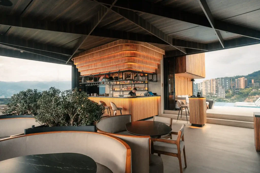 Etro rooftop bar at BINN Hotel with wood design and panoramic view of Medellín.