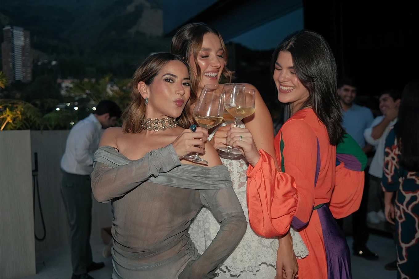 Tres mujeres brindando con copas de vino en la terraza de Etro Rooftop de Binn Hotel en Medellín.
