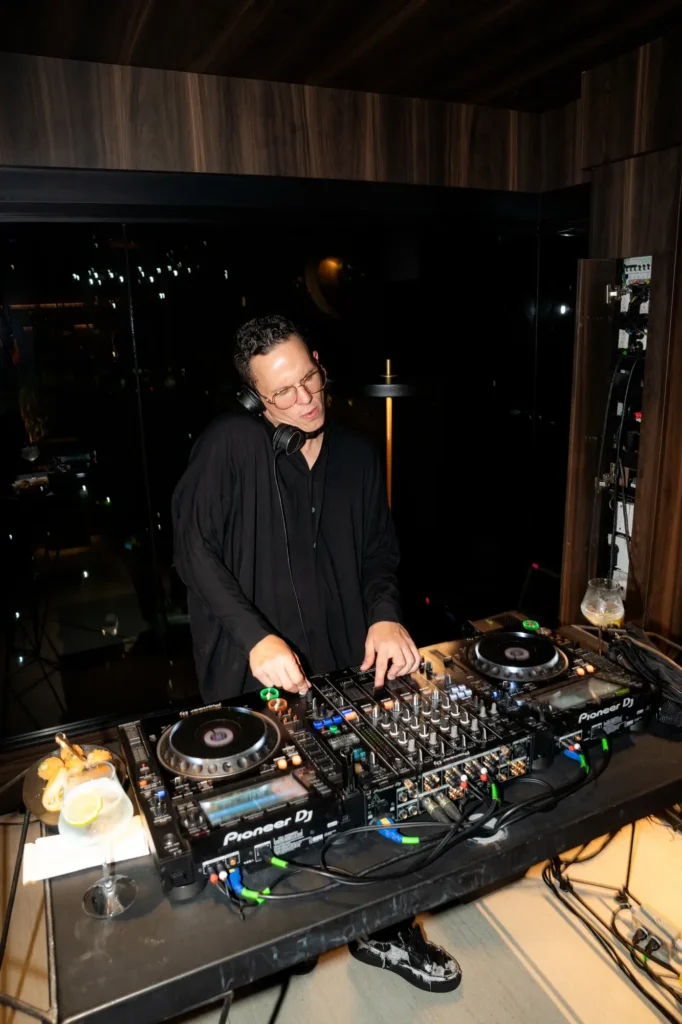 DJ performing a live set at Etro Rooftop in Binn Hotel Medellín with city lights in the background