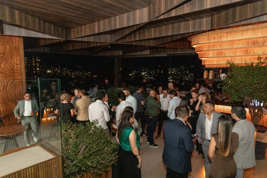 Evento cocktail con aforo completo en la terraza de Etro Rooftop de Binn Hotel en Medellín de noche.