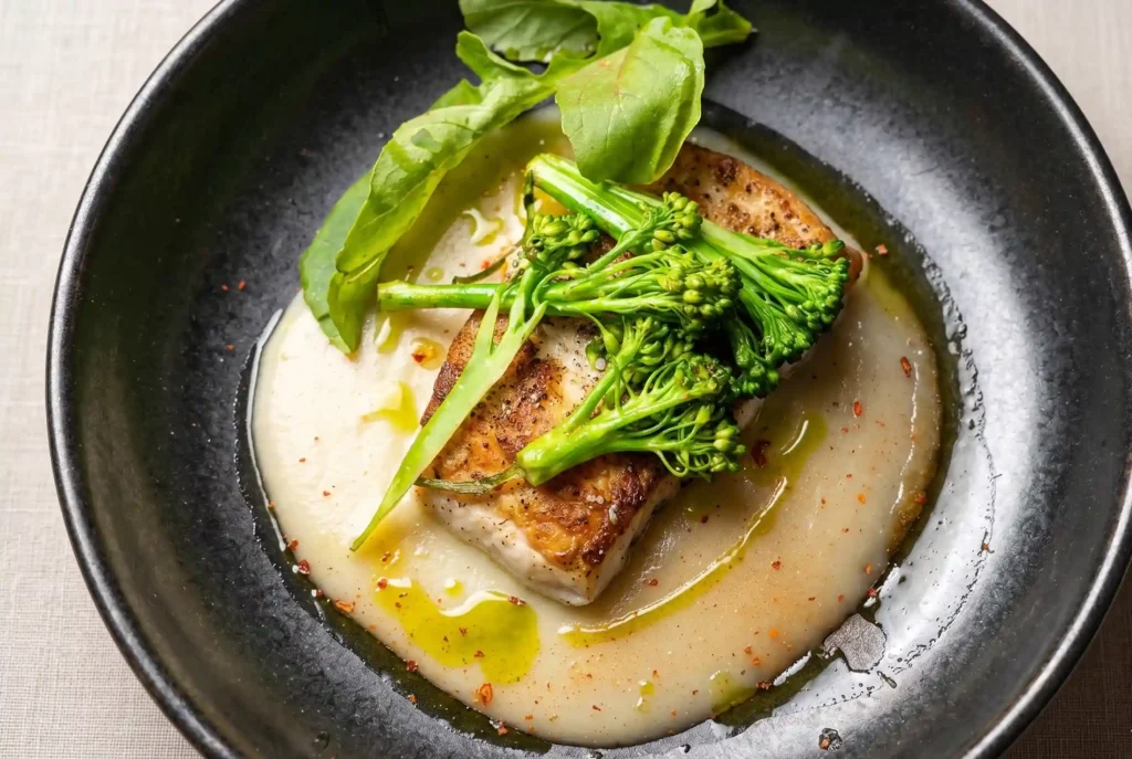 Filete de pescado sellado con crema, broccolini y albahaca en La Makha, restaurante en Medellín