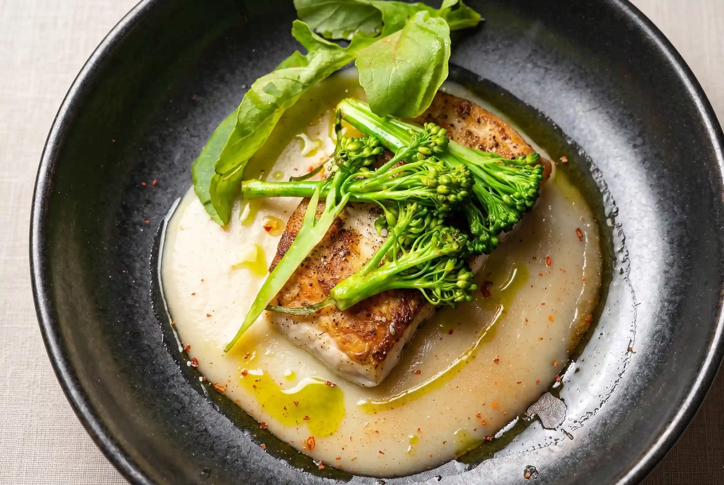Filete de pescado sellado con crema, broccolini y albahaca en La Makha, restaurante en Medellín