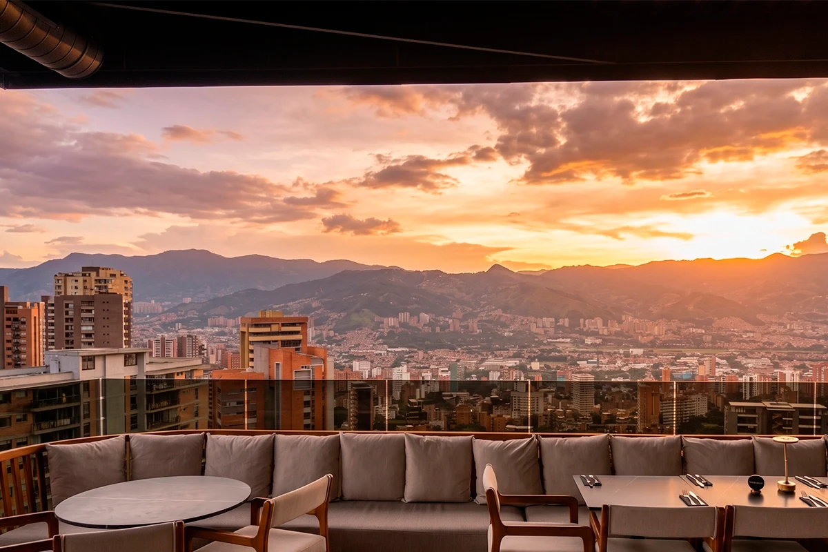 Atardecer dorado desde Etro Rooftop con vista panorámica de Medellín y sus montañas.