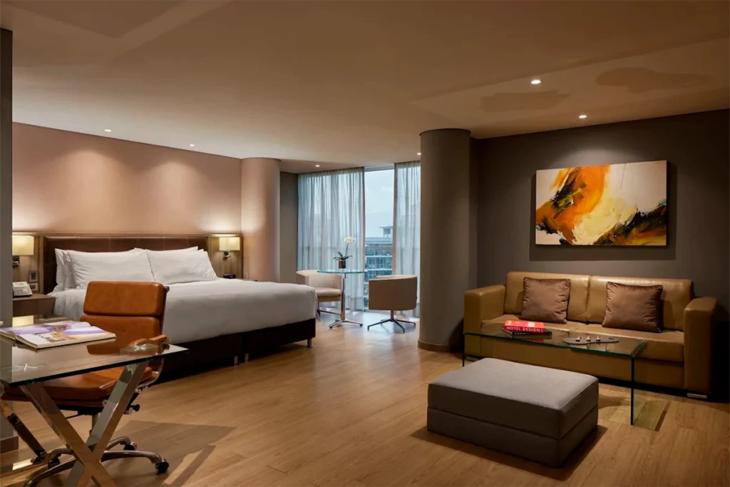 Junior Suite Deluxe City View at Binn Hotel with sitting area and skyline view