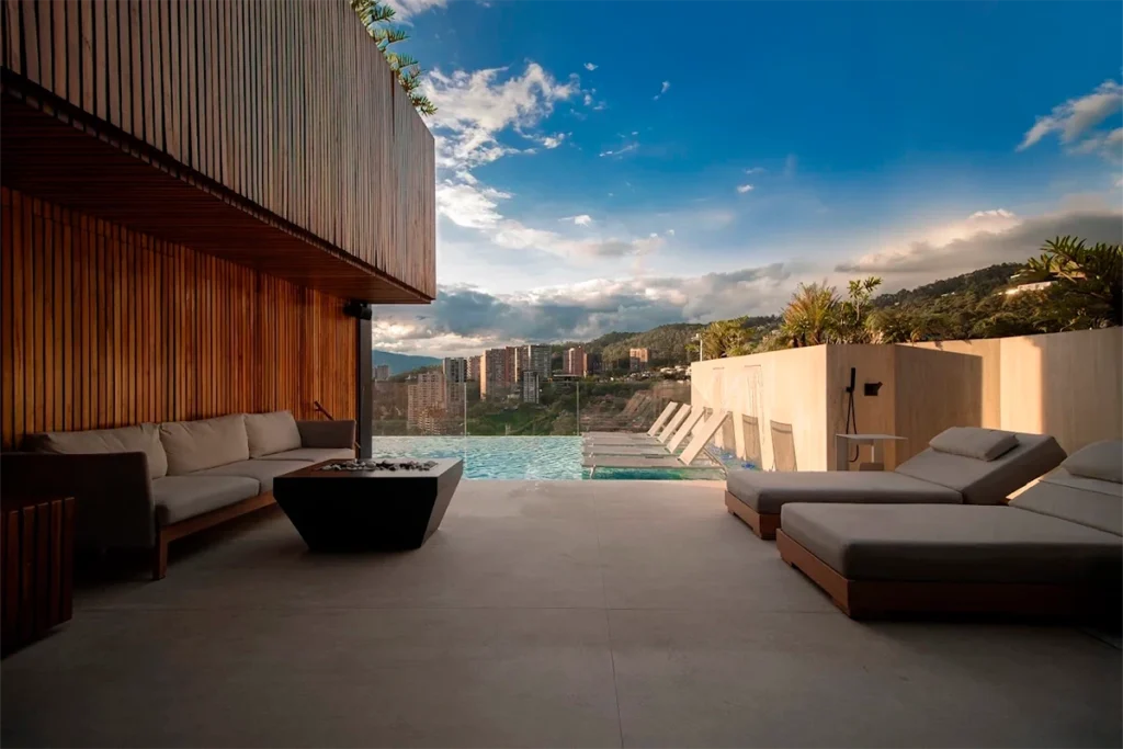 Piscina infinita del Binn Hotel con vista a las montañas de Medellín al atardecer.