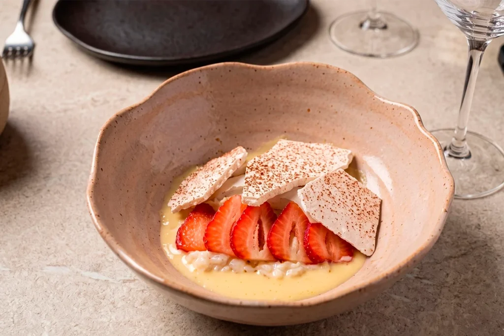 Postre de La Makha: arroz con leche, fresas frescas y teja de canela