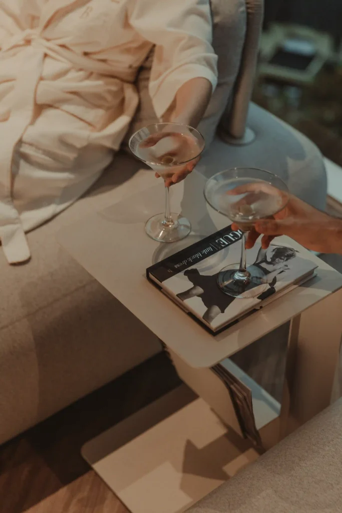 Guest wearing a bathrobe holding a martini glass next to a side table at Binn Hotel Medellin