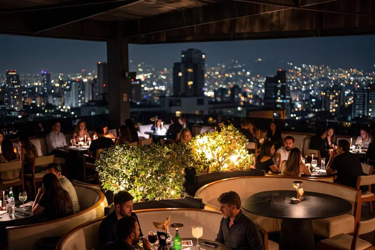 Crowded rooftop terrace at night with guests enjoying drinks and illuminated city skyline views at Etro Rooftop Medellín.