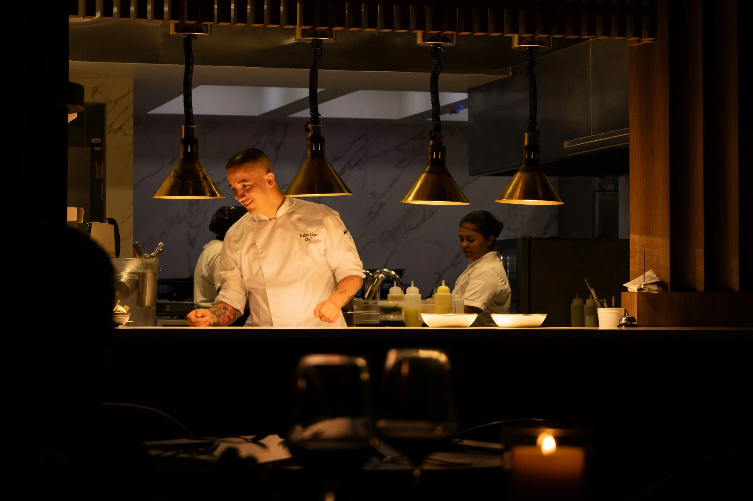 Executive chef Nelson Lopez smiling while working in the open kitchen of La Makha restaurant in Medellin.