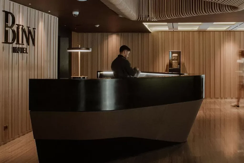 ormalidad.101Front desk agent working at the modern reception of Binn Hotel in El Poblado, operating normally.99