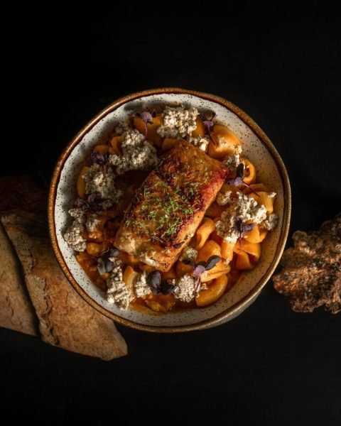 Un plato de comida fresca sobre una mesa negra, representando la filosofía de "De la pesca local al plato" en La Makha