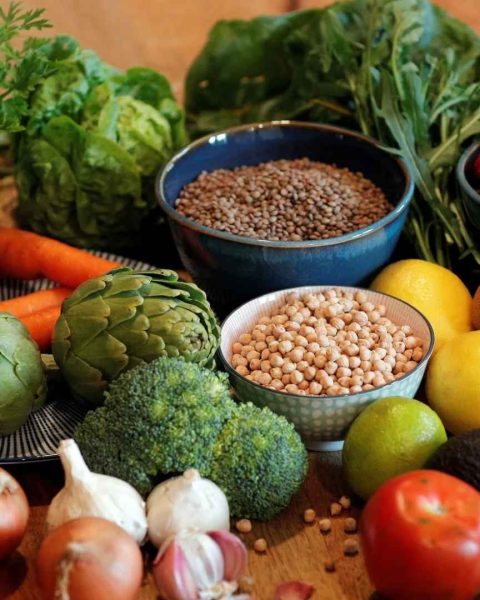 Variedad de frutas y verduras frescas dispuestas en una mesa, destacando la producción responsable y el apoyo a los productores