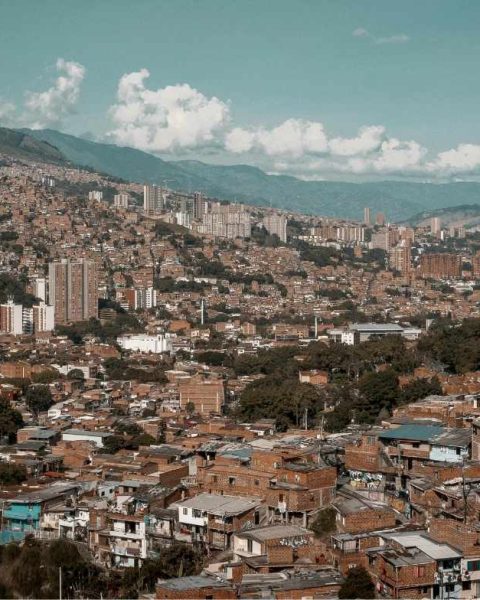 Medellin con numerosos edificios y montañas majestuosas al fondo, un lujo en el turismo