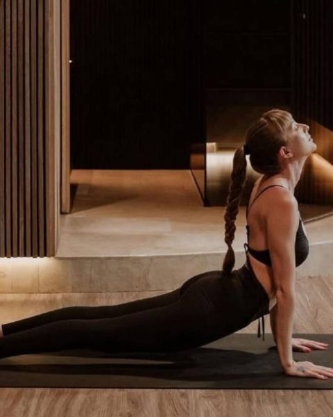 Mujer practicando yoga en una sala, promoviendo actividades de bienestar en Medellín