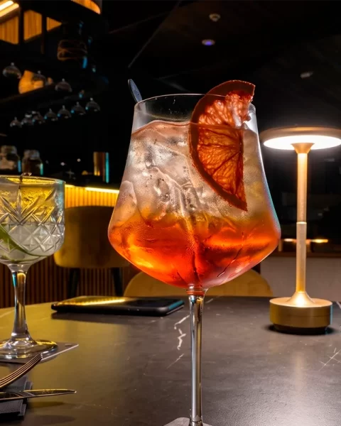 Aperol Spritz y cócteles clásicos sobre la mesa de la barra en Etro Rooftop.