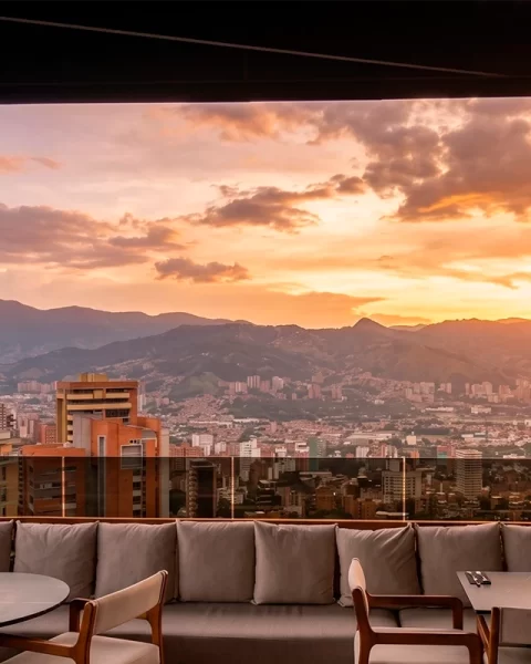 Atardecer dorado desde Etro Rooftop con vista panorámica de Medellín y sus montañas.