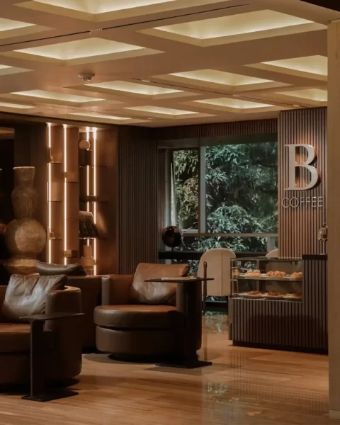 Lounge de B-Coffee con sillones de cuero y diseño moderno en un hotel de lujo en Medellín.