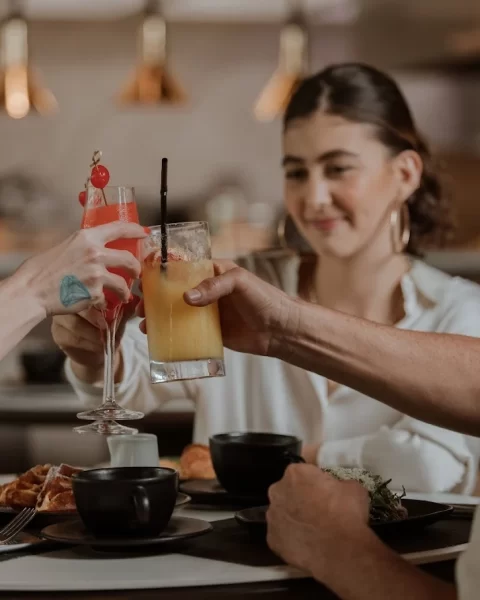 Tres personas brindando con cocteles coloridos en Etro Bar de BINN Hotel durante el Día del Padre