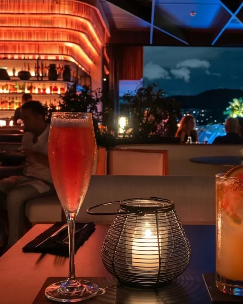 Cócteles de autor sobre mesa en Etro Rooftop de BINN Hotel con vista nocturna de Medellín al fondo