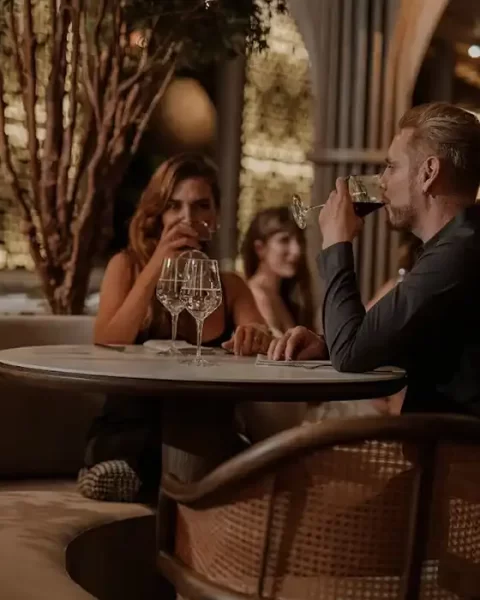 Pareja en cena romántica con vino en La Makha, restaurante de BINN Hotel, escapada romántica en Medellín mayo.