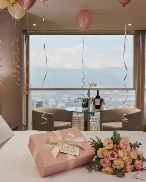 Habitación de BINN Hotel decorada con globos, rosas y regalo para el Día de las Madres, con vista a Medellín.